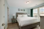 A 2nd level master bedroom retreat with a king-sized bed and attached ensuite bathroom.